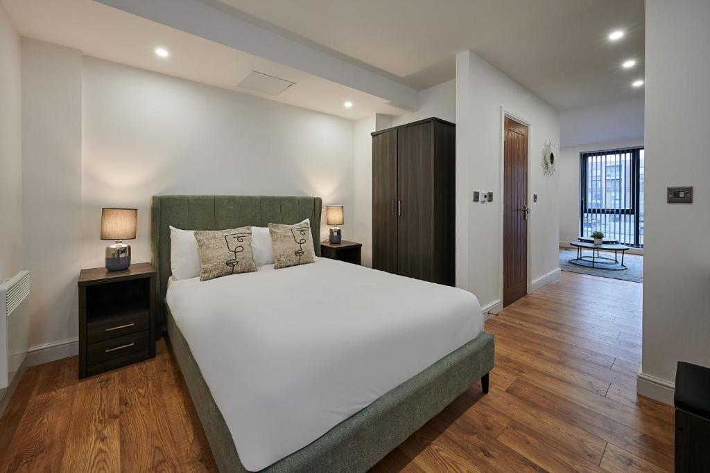 una camera da letto con un grande letto bianco e pavimenti in legno di Host & Stay - Sevenstays Aparthotel a Liverpool