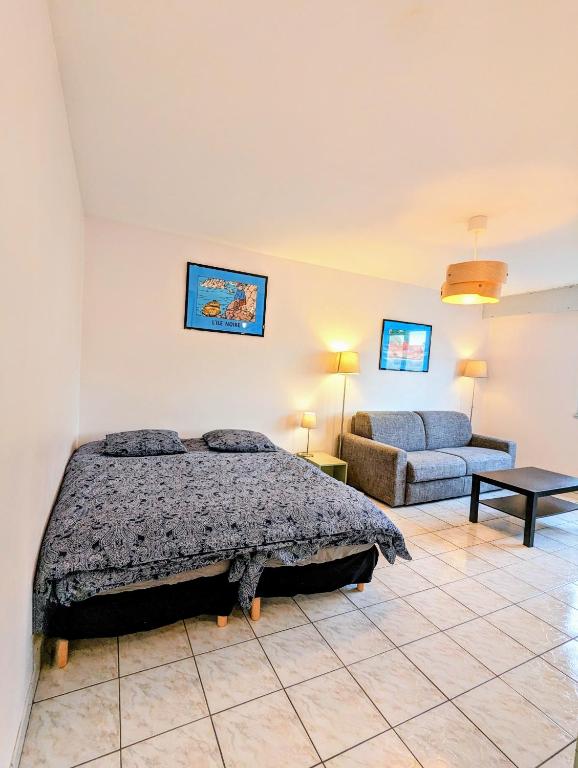 une chambre avec un lit et un canapé dans l'établissement CityCosy Strasbourg Studio MittelHaus, à Strasbourg