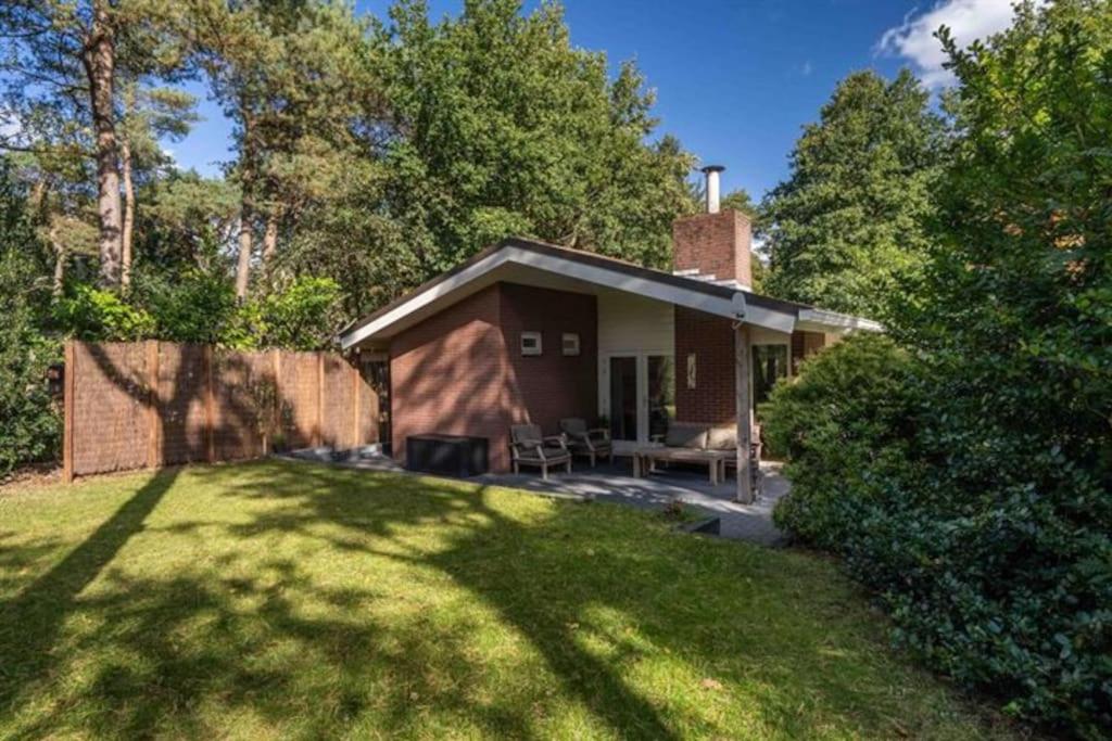 a small house with a yard with a grassy field at Huisje Elfde Wijk in Rheezerveen