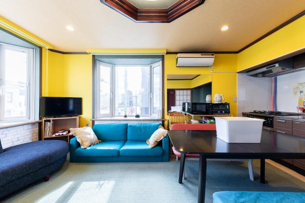 a living room with a blue couch and a table at Sprinkle inn - Vacation STAY 15784 in Sapporo