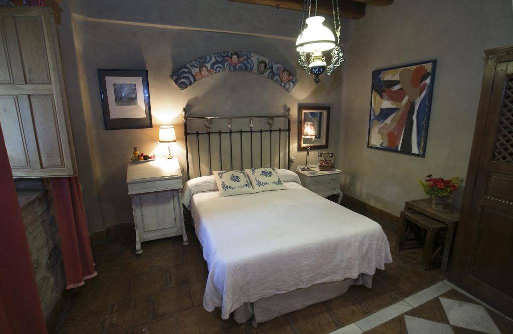 1 dormitorio con 1 cama con colcha blanca en Hotel BOUTIQUE HOCES DEL DURATON, en Sebúlcor
