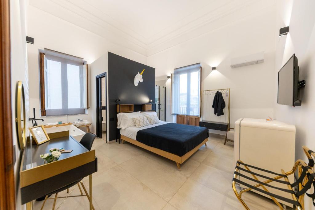 ein Schlafzimmer mit einem Bett und einem Schreibtisch in einem Zimmer in der Unterkunft Bohémien Boutique Guesthouse in Cefalú