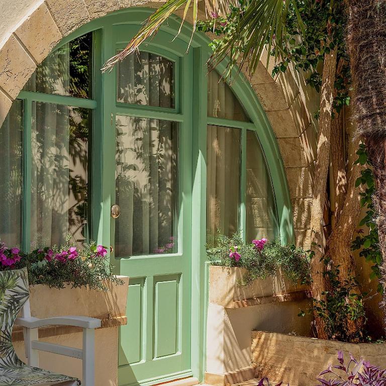 a green door on a building with potted plants at Mythos Suites Boutique Hotel in Rethymno