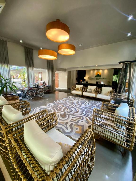 a living room with couches and chairs on a carpet at Hotel Terras da Finlândia in Penedo