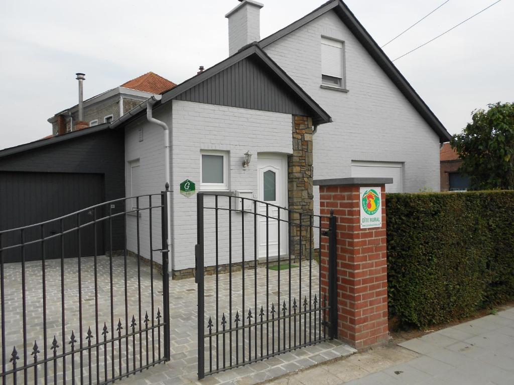 una valla frente a una casa con garaje en Gite de la Rhosnes, en Amougies