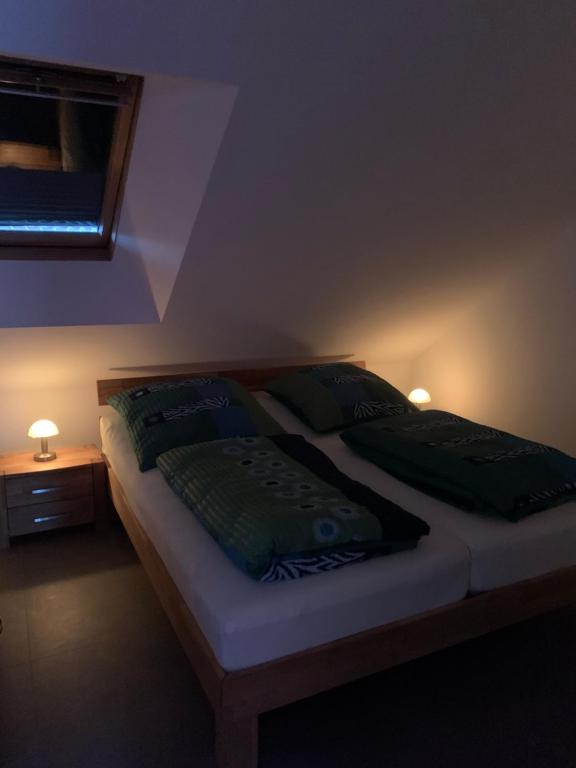 a bedroom with a bed with two green pillows at Sprem06 in Elsterheide