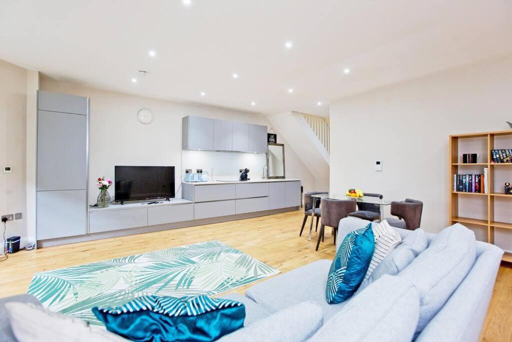 salon z białą kanapą i kuchnią w obiekcie Outstanding 1 bed duplex w Londynie