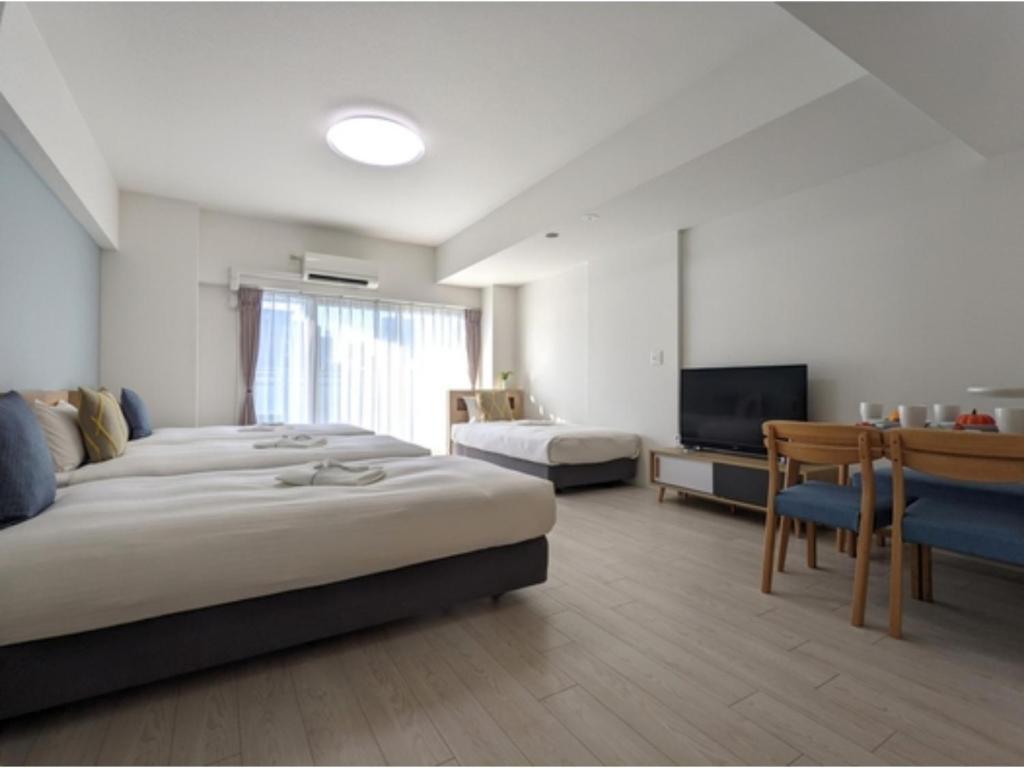 a hotel room with two beds and a flat screen tv at Eslead Hotel Osaka Tsuruhashi - Vacation STAY 77560v in Osaka