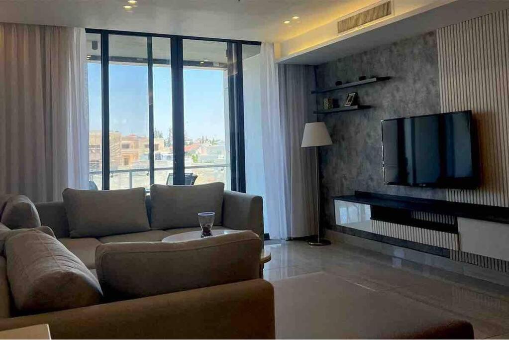 a living room with a couch and a flat screen tv at Luxury 2-bedroom Apartment Abdoun tower in Amman