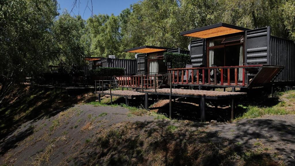eine Resortkabine mit einer Veranda und einer Terrasse in der Unterkunft Cabaña Habitainer BordeRio 3 in Concepción