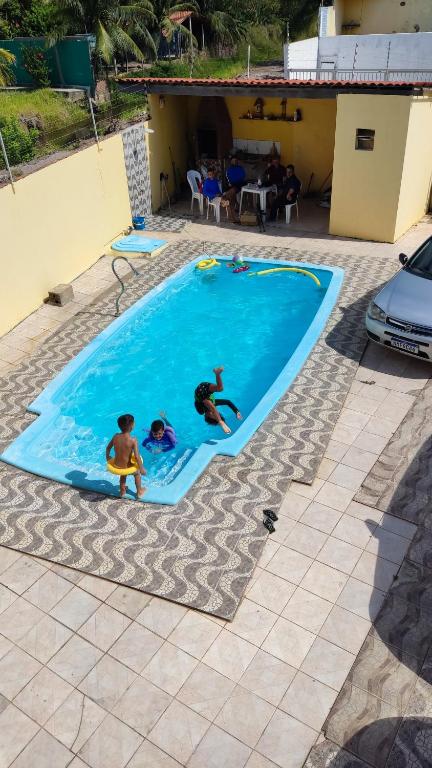 3 Leute spielen in einem Schwimmbad in der Unterkunft Casa na Barra de São Miguel -AL in São Miguel dos Campos