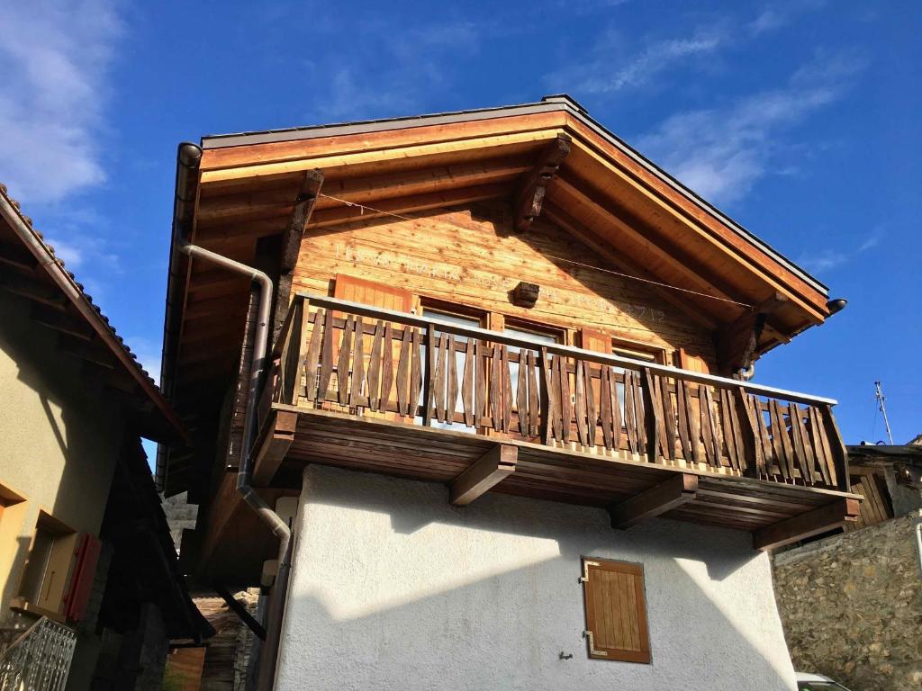 un balcón de madera en el lateral de un edificio en Chalet typique du Valais,Maison bio et bien-être! en Chermignon-dʼen Haut