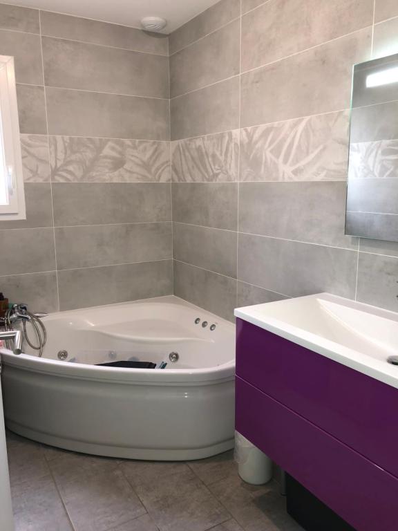une salle de bain avec une baignoire blanche et un lavabo dans l'établissement L’aureilhannaise, à Aureilhan