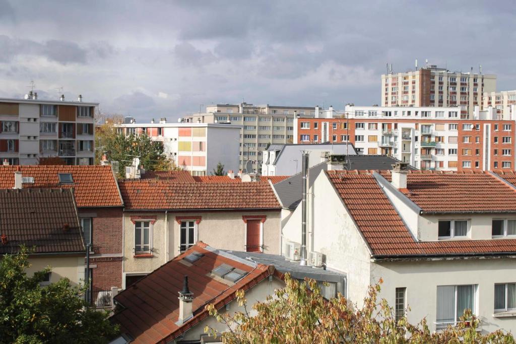 une vue sur les toits des bâtiments d'une ville dans l'établissement Lovely cozy cocoon at the gates of Paris, à Romainville