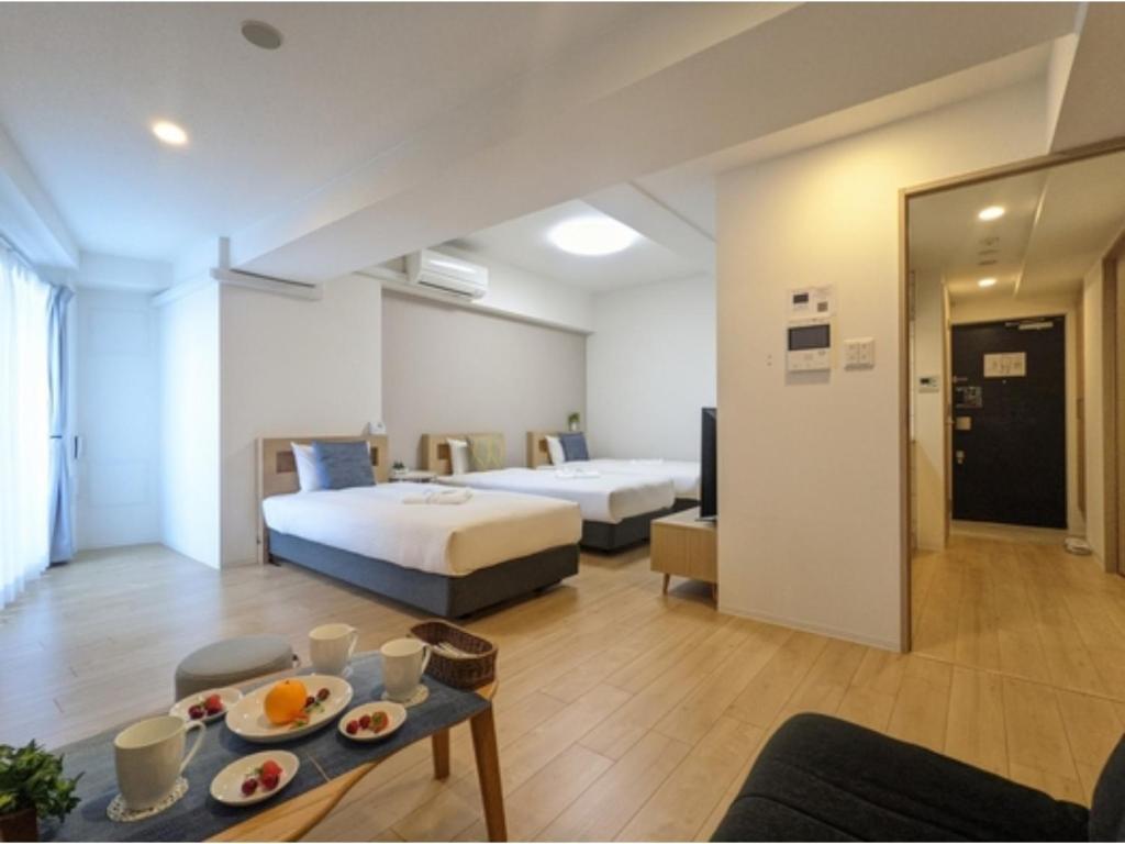 a hotel room with two beds and a table at Eslead Hotel Osaka Tsuruhashi - Vacation STAY 77488v in Osaka