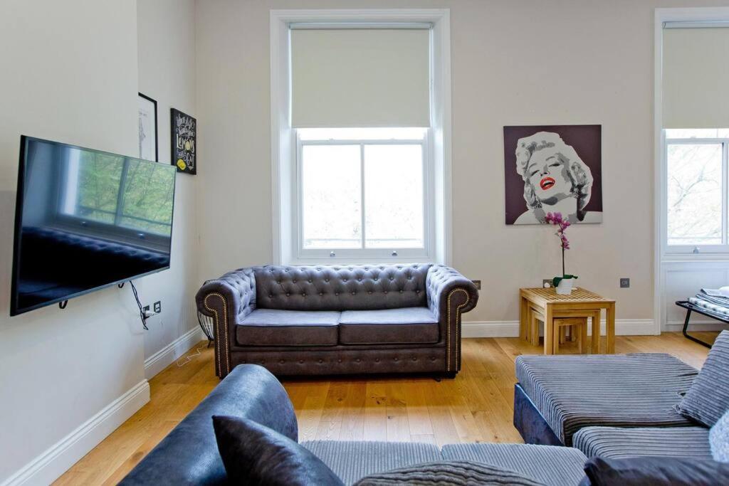 uma sala de estar com um sofá e uma televisão de ecrã plano em Stunning 1bed Kensington em Londres