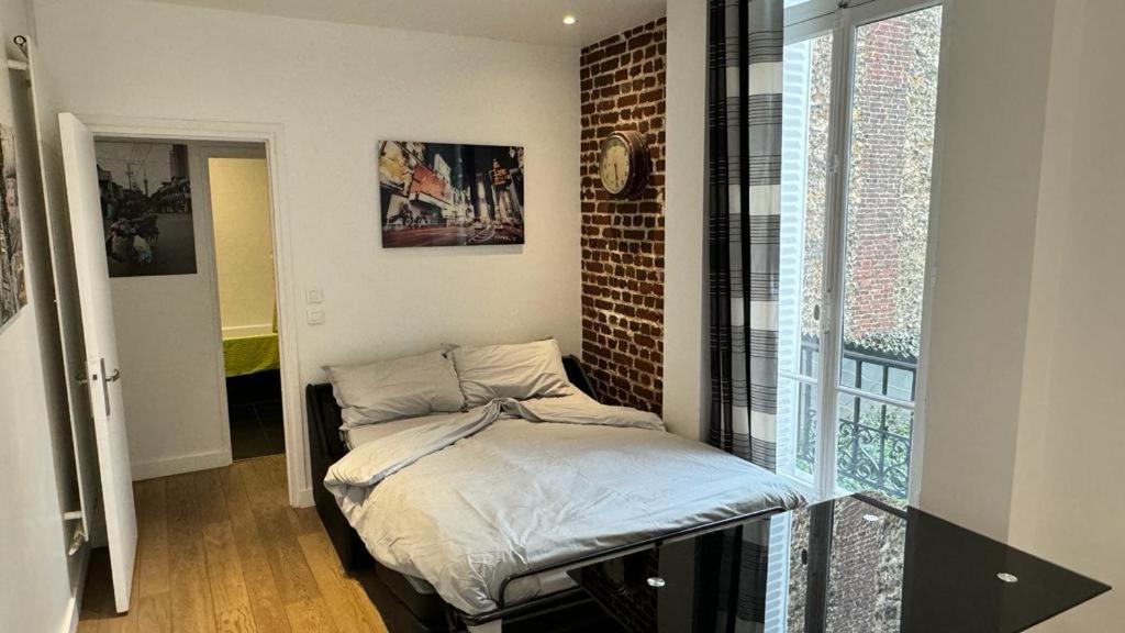 a small bed in a room with a brick wall at Gorgeous Paris Eiffel Tower in Paris