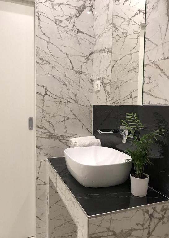 a bathroom with a white sink and a marble wall at Antares Luxury Rooms 2 in Split