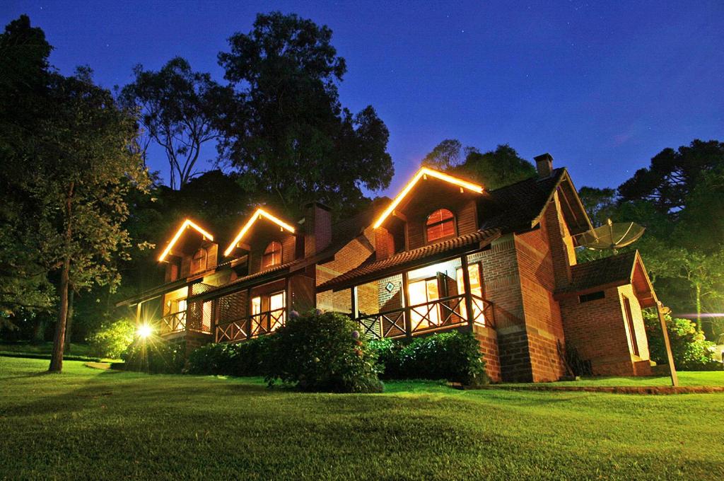 Una casa con luces en la parte delantera. en Chalets do Vale, en Gramado