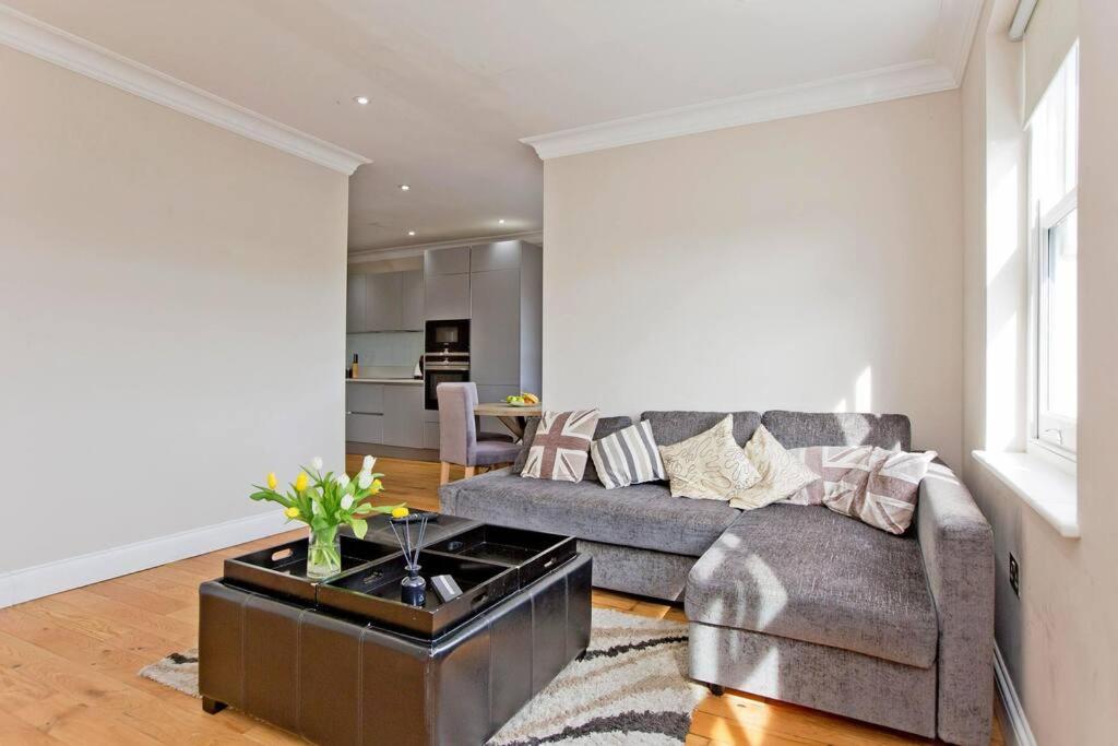 a living room with a couch and a table at Super 2bed Kensington in London