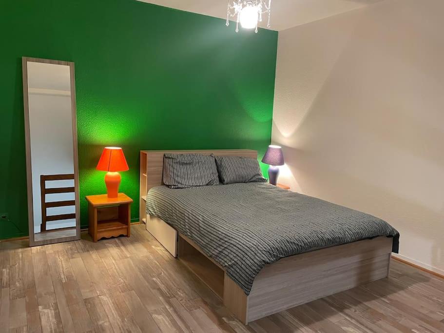 una camera verde con un letto e una parete verde di Appartement Duplex T1 ad Albertville