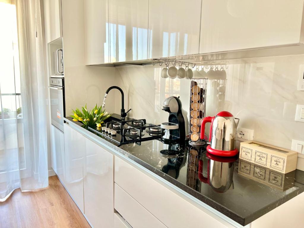 a kitchen with white cabinets and a black counter top at Corso Venezia in Mestre