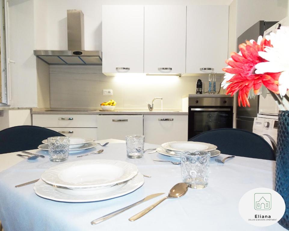 Eliana Deluxe & Modern Apartment في تورينو: طاولة مع صحون وادوات مطبخ
