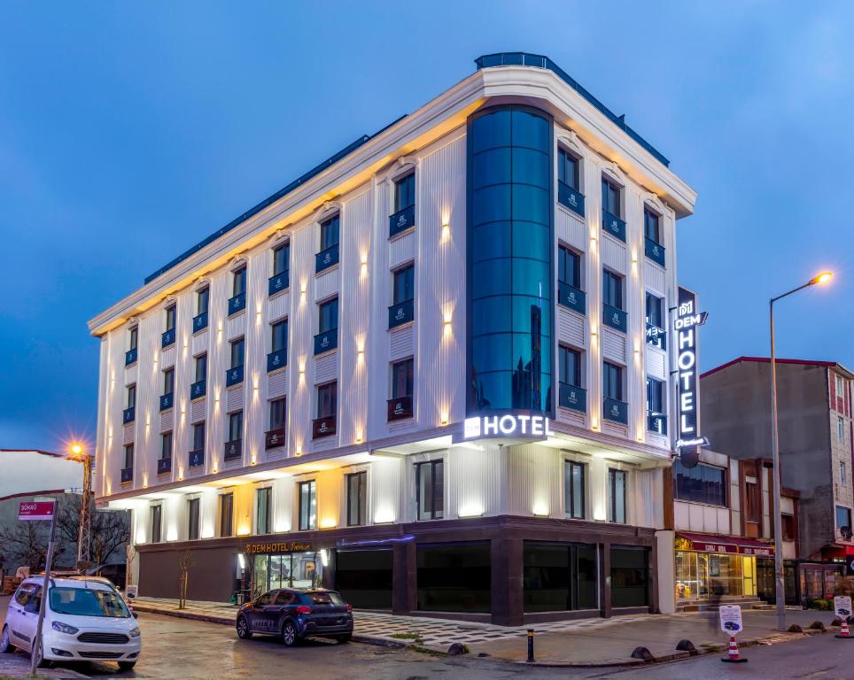 a hotel building with cars parked in a parking lot at Dem Premium Hotel - Round Trip Airport Service - Istanbul International Airport in Arnavutköy