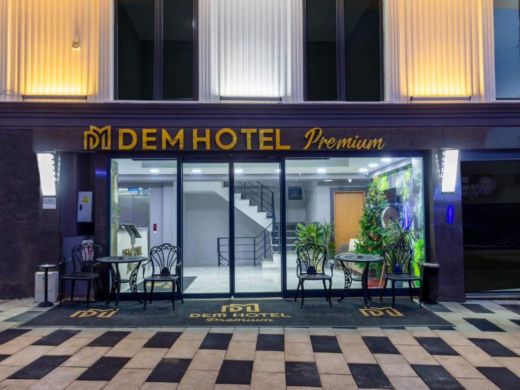 a hotel with tables and chairs in front of a building at Dem Premium Hotel - Round Trip Airport Service - Istanbul International Airport in Arnavutköy