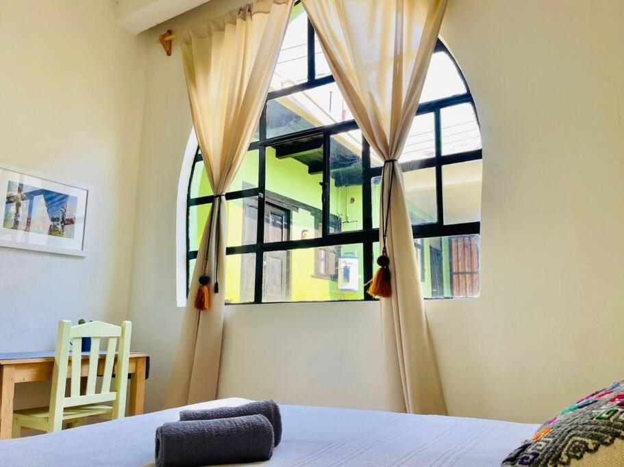 um quarto com uma cama e uma grande janela em Casa Matilda San Cristobal em San Cristóbal de Las Casas