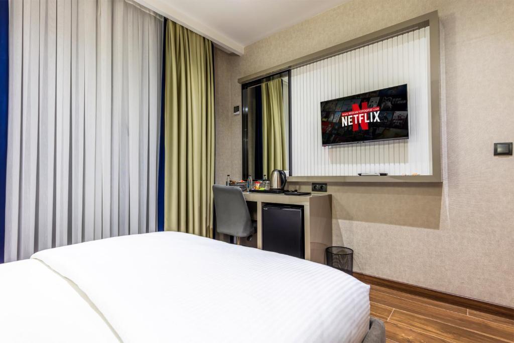 a hotel room with a bed and a television at Dem Premium Hotel - Round Trip Airport Service - Istanbul International Airport in Arnavutköy