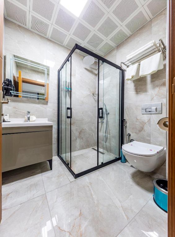 a bathroom with a shower and a toilet and a sink at Dem Premium Hotel - Round Trip Airport Service - Istanbul International Airport in Arnavutköy