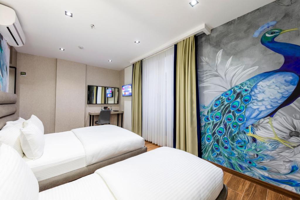 a hotel room with two beds and a peacock mural at Dem Premium Hotel - Round Trip Airport Service - Istanbul International Airport in Arnavutköy