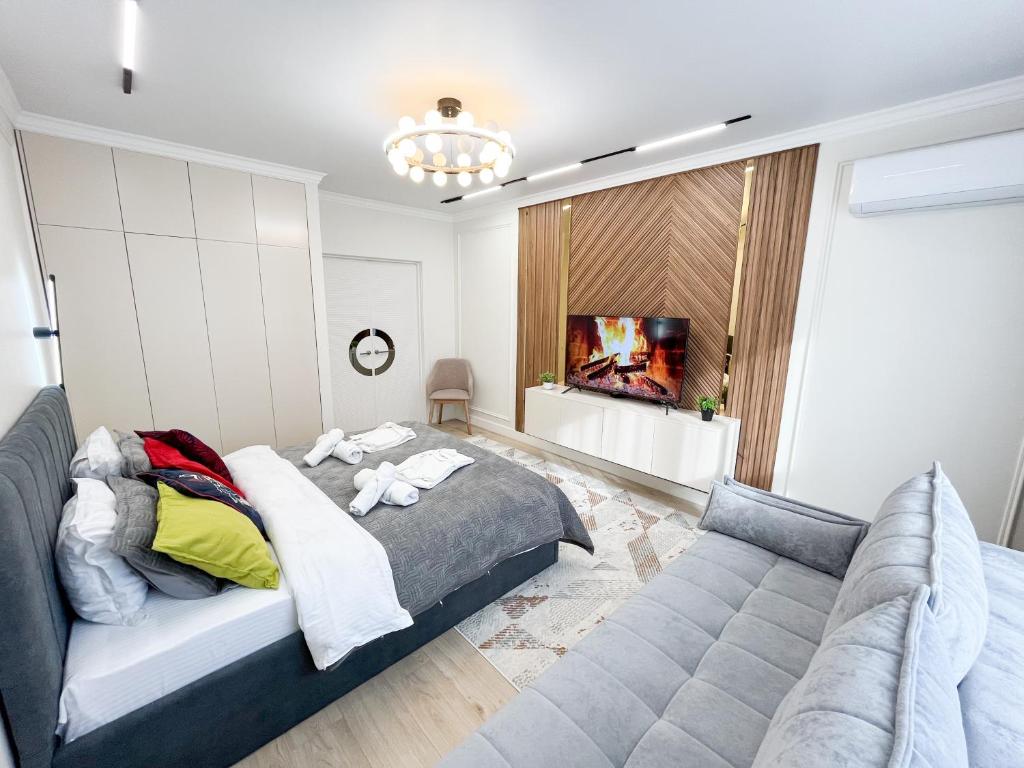 a bedroom with a bed and a couch at ЖК "4You" one room apartment in Almaty