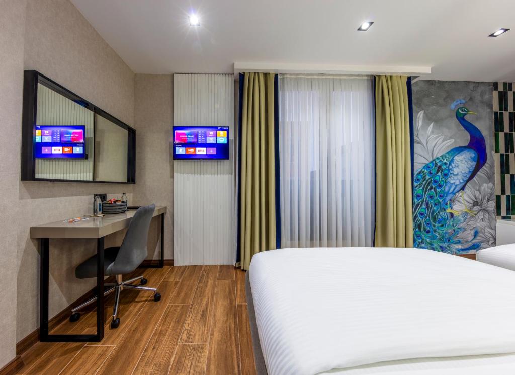 a hotel room with a bed and a desk and a computer at Dem Premium Hotel - Round Trip Airport Service - Istanbul International Airport in Arnavutköy