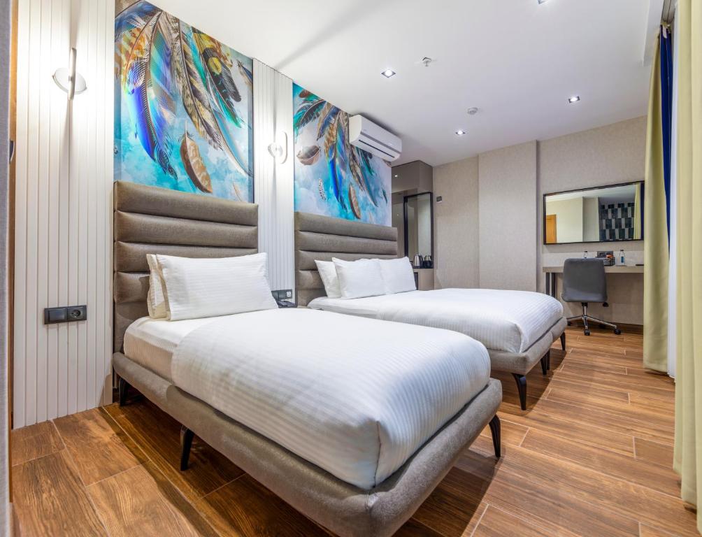 two beds in a room with a painting on the wall at Dem Premium Hotel - Round Trip Airport Service - Istanbul International Airport in Arnavutköy