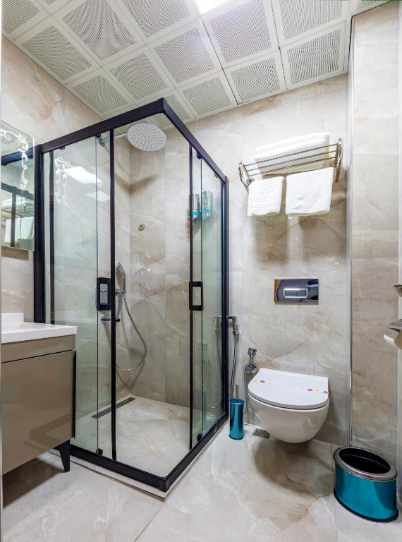 a bathroom with a glass shower and a toilet at Dem Premium Hotel - Round Trip Airport Service - Istanbul International Airport in Arnavutköy