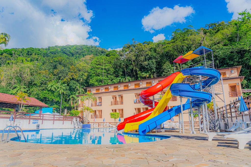 a slide in a swimming pool at a resort at Água Doce Praia Hotel in Ubatuba