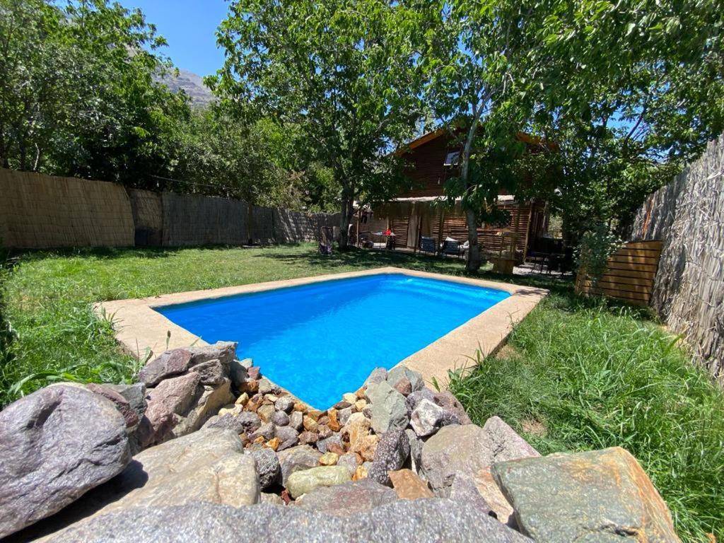 einen Pool in einem Garten mit Felsen in der Unterkunft Cabaña en San Jose de Maipo in Melocotón