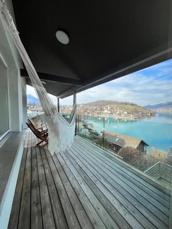 een hangmat op een terras met uitzicht op het water bij Wohnung mit grossartiger Seesicht und Balkon in Spiez