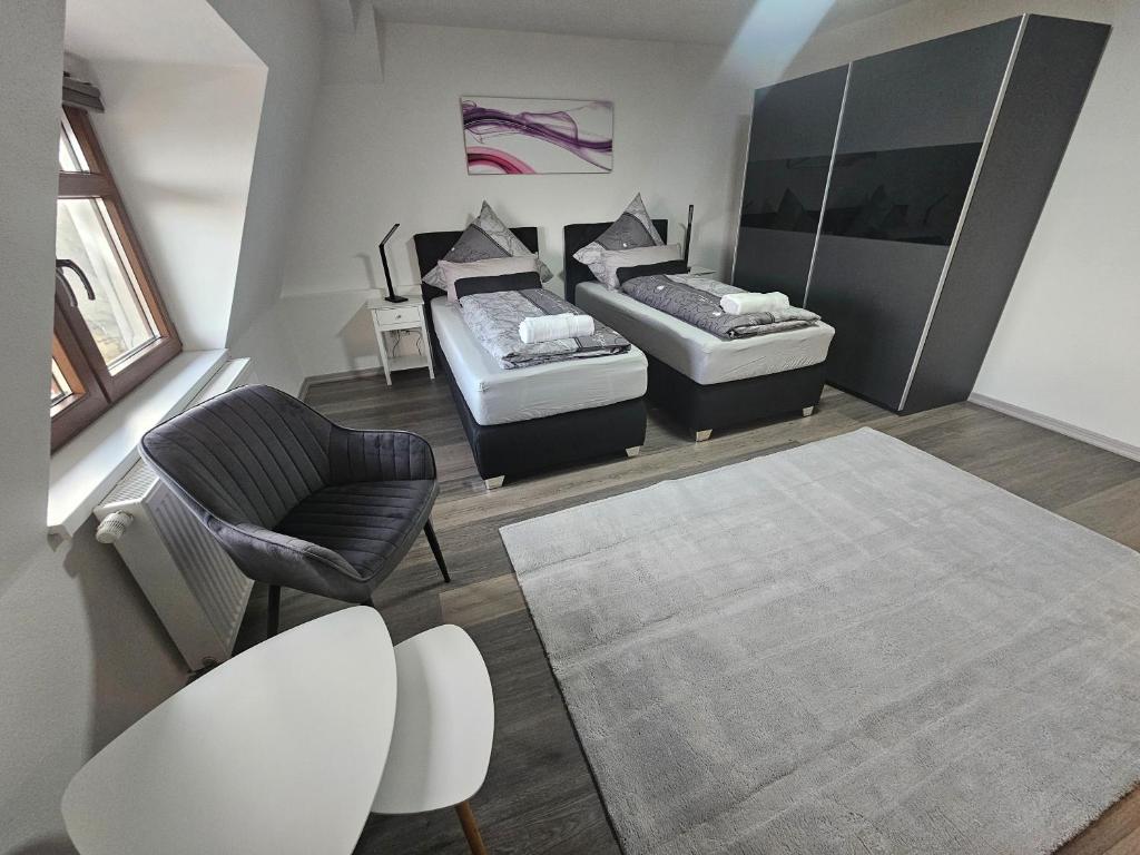 a living room with two beds and a chair at Suite Dari in Bernburg