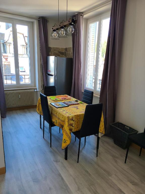 a dining room table with a yellow table cloth at Appartement confortable à La Bourboule, 64 m², balcons agréables in La Bourboule
