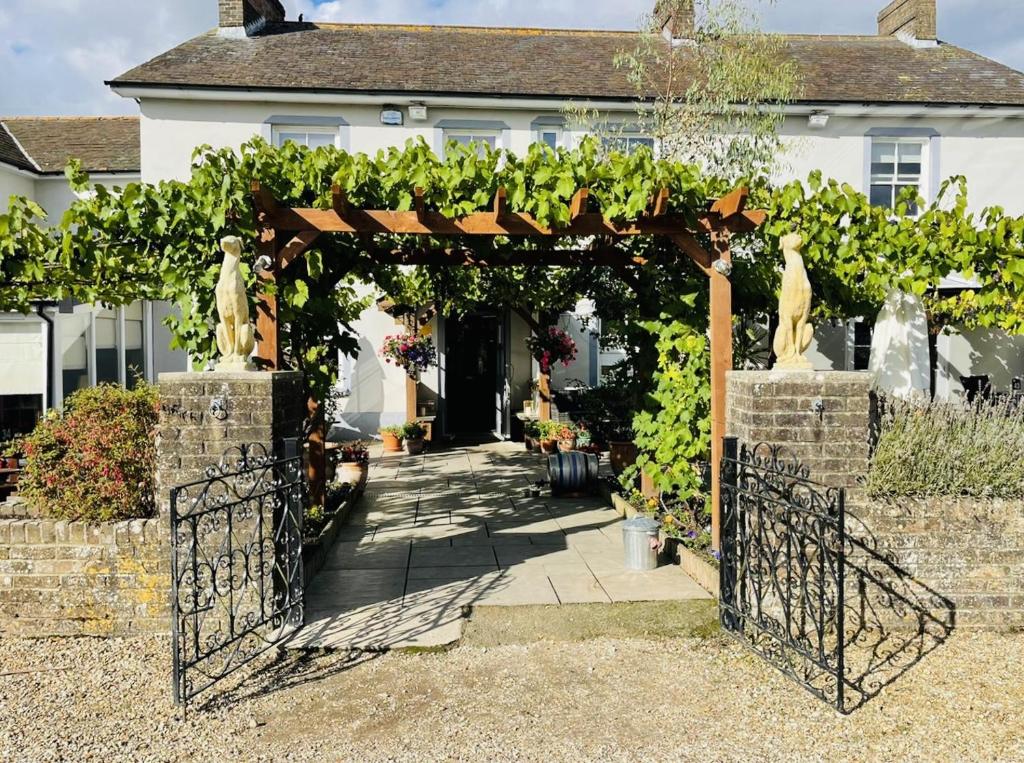 wejście do domu z altaną wypełnioną winoroślą w obiekcie The Greyhound Inn w mieście Dorchester