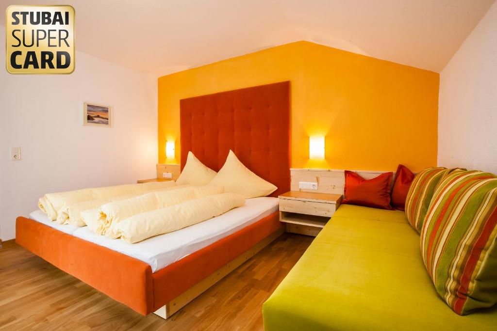 a bedroom with a large bed and a yellow wall at Pension Alpina Neustift in Neustift im Stubaital