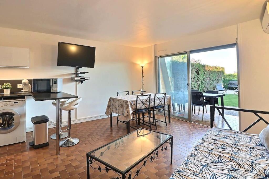 un salon avec une cuisine et un salon avec une table dans l'établissement Petit coin de paradis à deux pas de la mer jardin, à La Ciotat