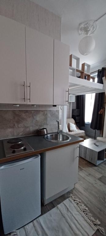 une cuisine avec des armoires blanches et un évier dans l'établissement Studio hyper centre entre port et remblai, à Les Sables-dʼOlonne