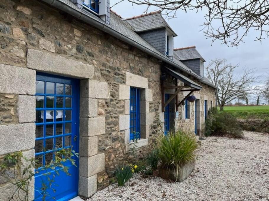 une maison en pierre avec des portes bleues et une cour dans l'établissement P’tite Raguenne, à Plouha