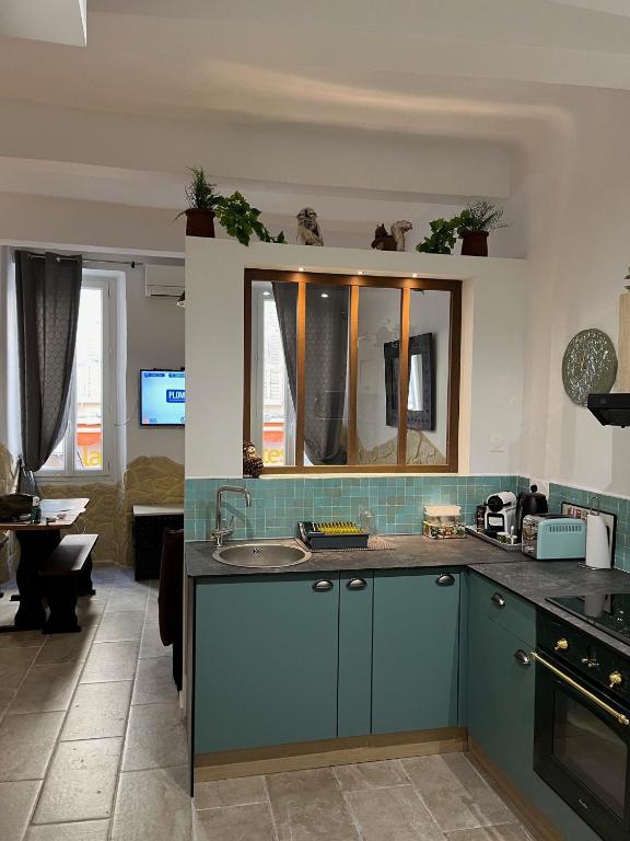 une cuisine avec un évier et un salon dans l'établissement Logis centre historique 4 personnes - Soleil Levant La Ciotat, à La Ciotat