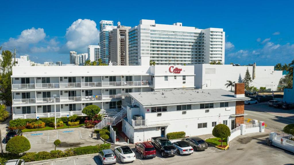 un grande edificio bianco con auto parcheggiate in un parcheggio di Collins Hotel a Miami Beach