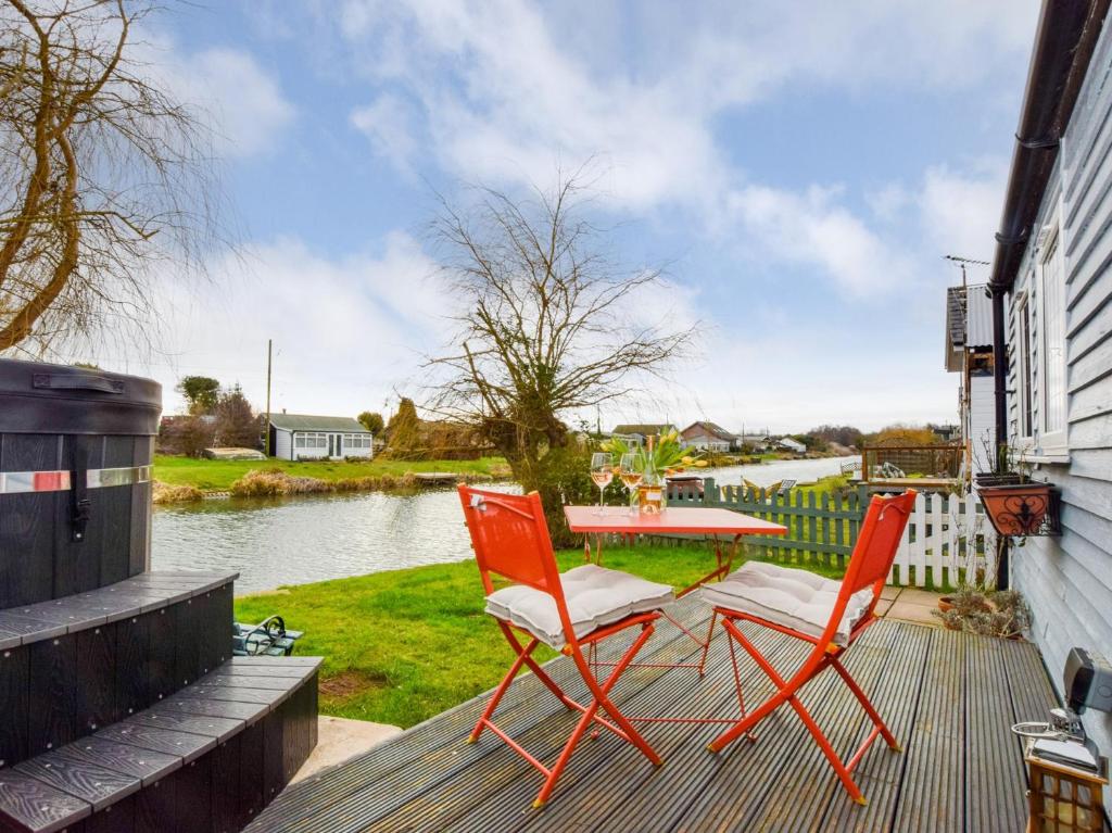two chairs and a table on a deck next to a river at 1 bed in Spalding 75073 in Surfleet
